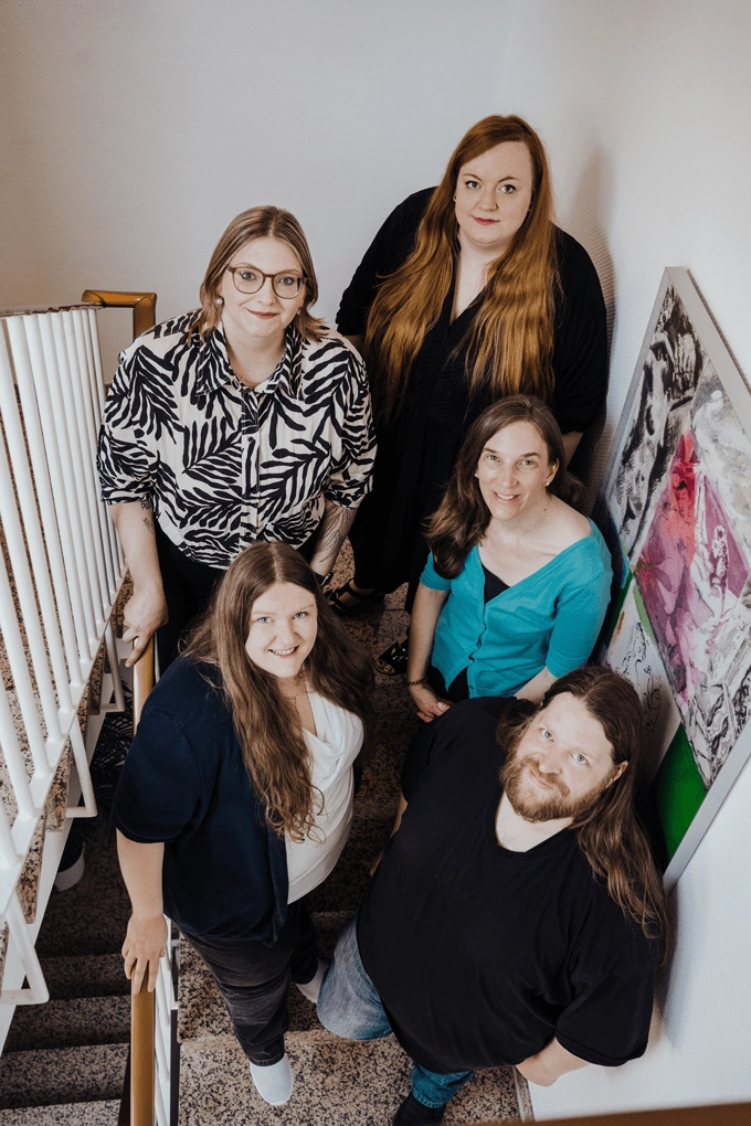 team-kahawa-hochformat Hochkant-Foto mit dem Team von Kia Kahawa Verlagsdienstleistungen: Marcel, Anke, Kia, Christian und Bente stehen auf einer Treppe, Fotografie von oben.