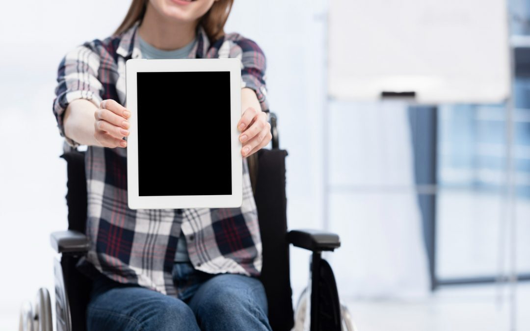 Ein Mädchen in einem Rollstuhl hält barrierefreie E-Books in die Kamera.